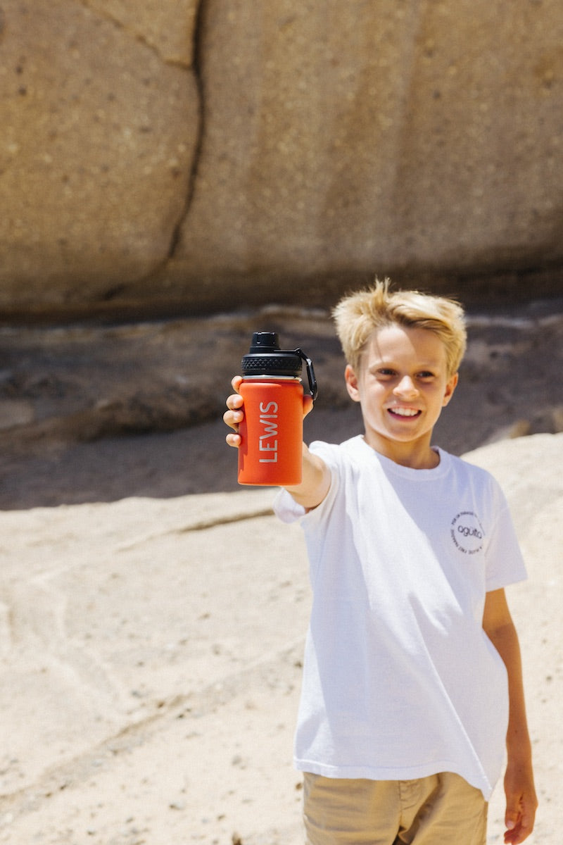 A young boy showing a personalised Agüita bottle in his hand